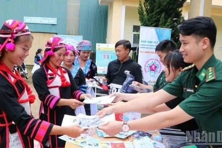 Phát tờ rơi tuyên truyền nhằm nâng cao nhận thức về phòng, chống mua bán người ở biên giới Lai Châu.(Ảnh: Bộ đội Biên phòng)