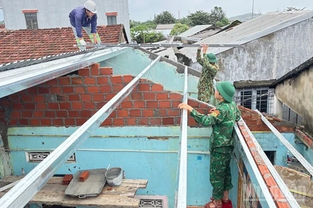 Cán bộ và chiến sĩ Đồn Biên phòng cửa khẩu cảng Dung Quất sửa chữa, xây dựng nhà cho người dân ven biển.