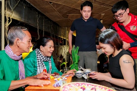 Vợ chồng nghệ nhân Trương Thị Chiều hướng dẫn du khách trải nghiệm làm bánh dân gian.