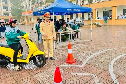 Cán bộ Phòng cảnh sát giao thông tỉnh Lào Cai hướng dẫn tập sa hình đối với học sinh xã Văn Chấn. (Ảnh: THANH SƠN)