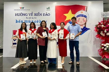 Nhà thơ, nhà báo Huỳnh Mai Liên (mặc áo dài trắng) trong buổi ra mắt tập thơ "Bốn mùa cờ bay". 