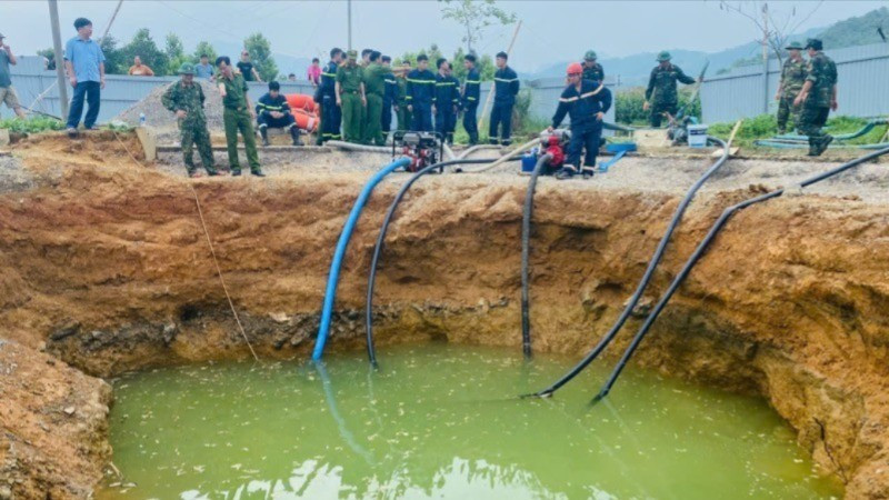 Lực lượng chức năng bơm hút nước tìm kiếm nạn nhân. (Ảnh: TUẤN SƠN)