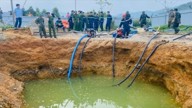 Lực lượng chức năng bơm hút nước tìm kiếm nạn nhân. (Ảnh: TUẤN SƠN)