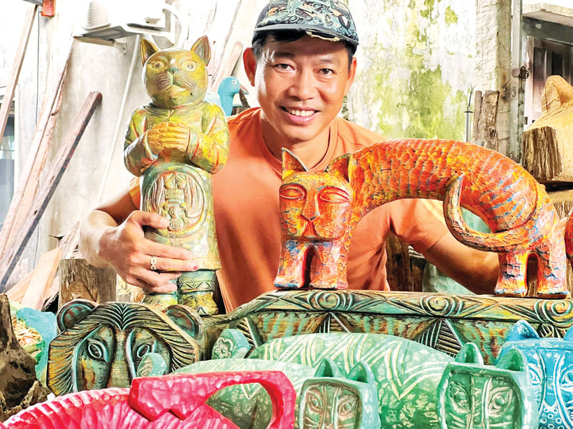 Anh Lê Ngọc Thuận bên một số tác phẩm từ củi lũ. (Ảnh: NVCC)