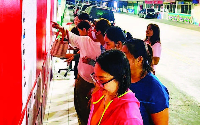 Công nhân Công ty TNHH Pouyuen Việt Nam tìm hiểu tiểu sử của các ứng cử viên được niêm yết tại khu vực nhà máy.