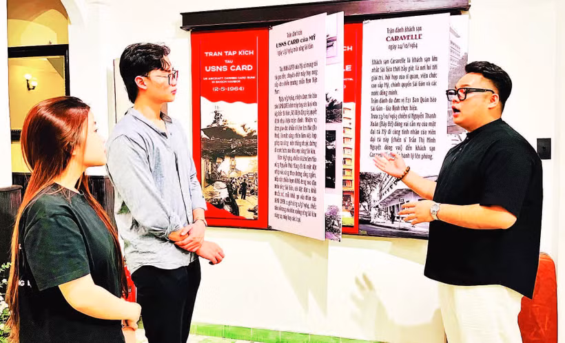 Anh Trần Trọng Nghĩa (bên phải) đang giới thiệu với khách tham quan về các trận đánh của các chiến sĩ Biệt động Sài Gòn-Gia Định tại bảo tàng.