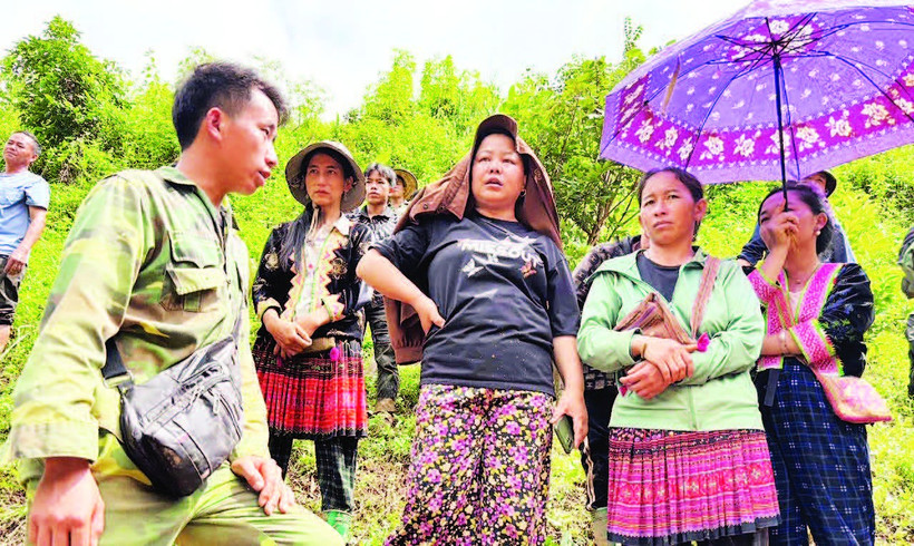 Trưởng bản Mùa A Thi (ngoài cùng, bên trái) trao đổi với người dân trong bản. (Ảnh VŨ LỢI)