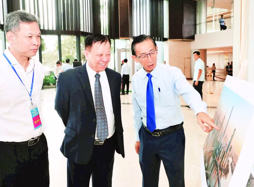 Các đại biểu tham quan triển lãm ảnh mô phỏng Trung tâm Tài chính quốc tế tại Thành phố Hồ Chí Minh. (Ảnh HOÀNG TRIỀU)