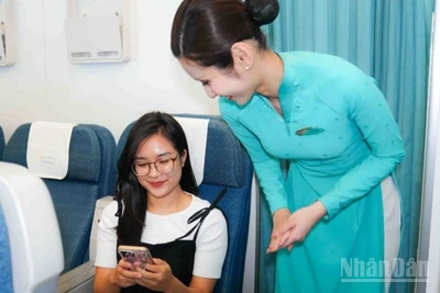 Tiếp viên Vietnam Airlines hướng dẫn hành khách sử dụng internet trên chuyến bay.