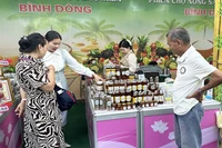 Người dân và khách tham quan tìm mua đặc sản tại một gian hàng của tỉnh Đồng Tháp trong phiên chợ.