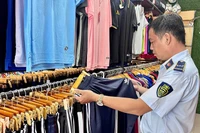 Lực lượng quản lý thị trường thành phố kiểm tra một điểm kinh doanh sản phẩm thời trang vi phạm. (Ảnh CTV).