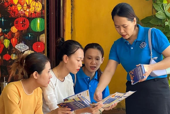 Cán bộ Bảo hiểm xã hội tuyên truyền chính sách bảo hiểm xã hội, bảo hiểm y tế cho người lao động phường Hội An (tỉnh Quảng Nam).