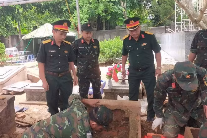 Các lực lượng tham gia lấy mẫu hài cốt liệt sĩ tại nghĩa trang liệt sĩ Tuần Giáo. (Ảnh: ĐỨC HẠNH)