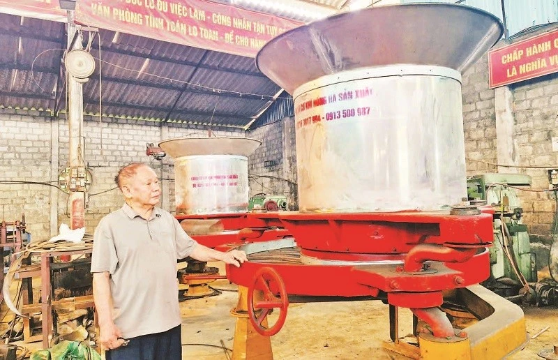 Bác Vũ Hữu Lê bên sản phẩm máy vò chè đa năng.