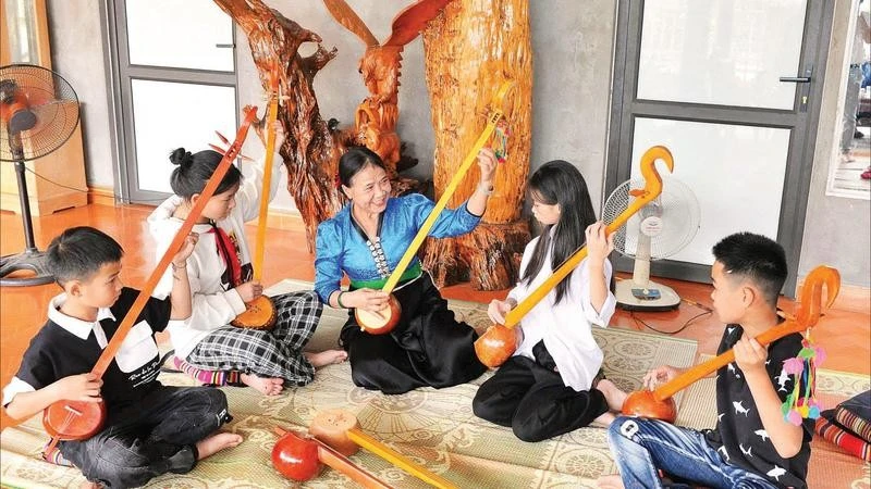 Bà Tòng Thị Thân chỉ dạy từng động tác đàn tính cho các học viên nhí.