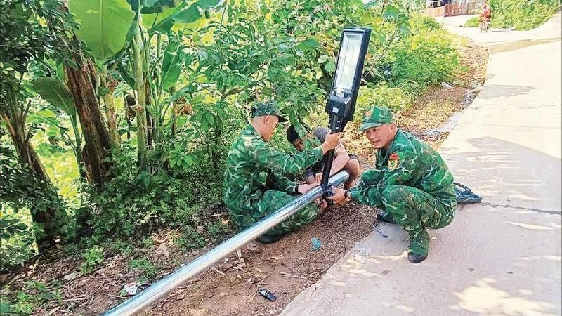 Cán bộ, chiến sĩ Đồn Biên phòng Bắc Xa lắp cột đèn năng lượng tại thôn Bản Hang, xã Kiên Mộc.
