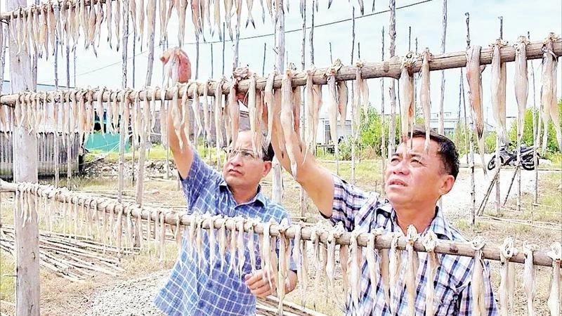 Chủ một cơ sở sản xuất kiểm tra chất lượng sản phẩm.