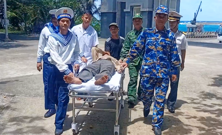 Cán bộ, chiến sĩ đảo Trường Sa đưa ngư dân Nguyễn Văn Lai lên đảo cấp cứu. 2.png