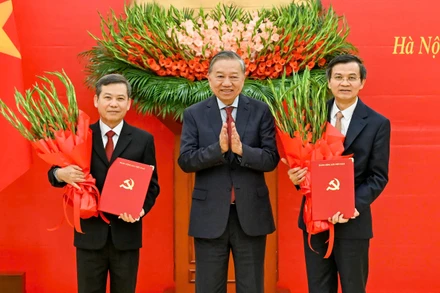 Tổng Bí thư Tô Lâm trao Quyết định của Bộ Chính trị và tặng hoa chúc mừng các đồng chí Lê Minh Trí và Đoàn Minh Huấn. (Ảnh: DUY LINH)