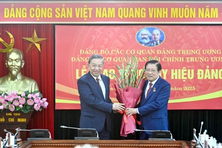 Tổng Bí thư Tô Lâm trân trọng trao Huy hiệu 45 năm tuổi đảng và chúc mừng đồng chí Phan Đình Trạc. (Ảnh: ĐĂNG KHOA)