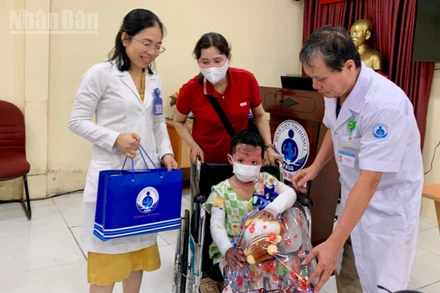 Bác sĩ Bệnh viện Nhi đồng 1 tặng quà cho bé T.