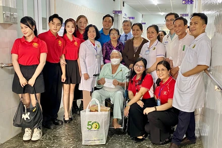 Y bác sĩ trao quà cho bệnh nhân lớn tuổi tại Viện Y dược học dân tộc Thành phố Hồ Chí Minh.