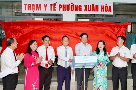 Đại biểu bấm nút đưa Trạm y tế Xuân Hòa vào hoạt động. 