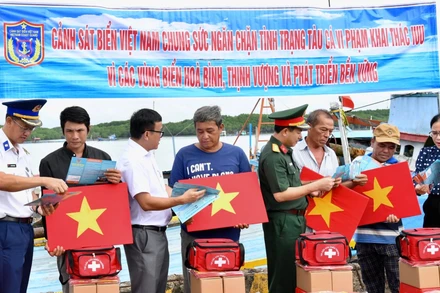 Cảnh sát biển trao cờ Tổ quốc và phát tờ rơi tuyên truyền cho ngư dân tại xã Thạnh An.