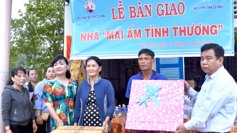 Đại diện Công ty trách nhiệm hữu hạn một thành viên Xổ số kiến thiết Cà Mau trao quà an sinh xã hội cho người dân vùng nông thôn.