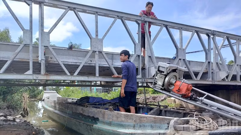 Một ghe tải phải chờ con nước xuống mới có thể đưa phương tiện vào ruộng muối vận chuyển hàng.