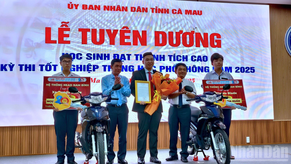 Đại diện đơn vị tài trợ trao tặng 2 chiếc xe gắn máy cho 2 thủ khoa của tỉnh Cà Mau. ndo_br_hs-5-312.jpg