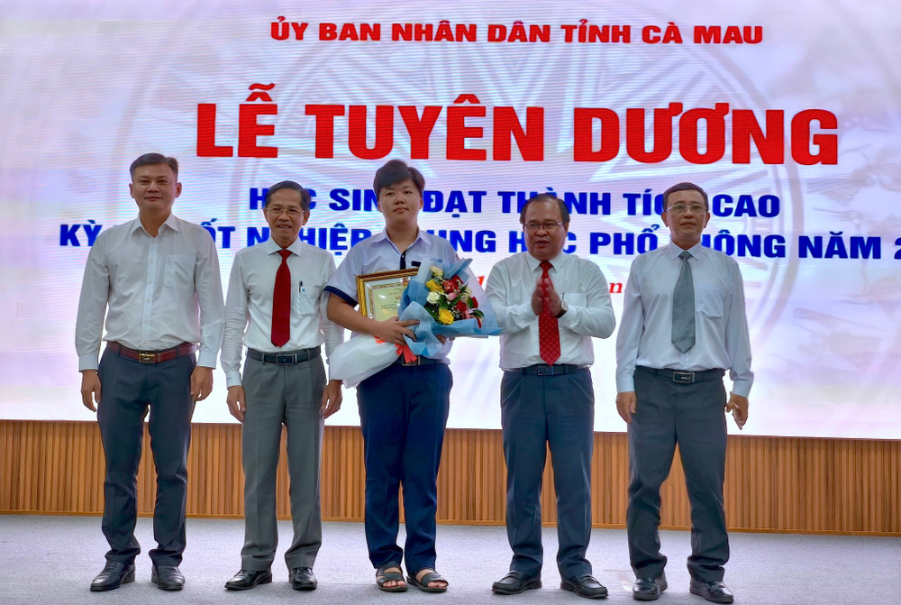 Một trong 2 thủ khoa của tỉnh Cà Mau (giữa) được tuyên dương tại buổi lễ. hs-8.jpg