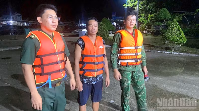 Cán bộ, chiến sĩ Đồn Biên phòng Khánh Hội cứu vớt ngư dân gặp nạn (giữa) đưa vào bờ an toàn.