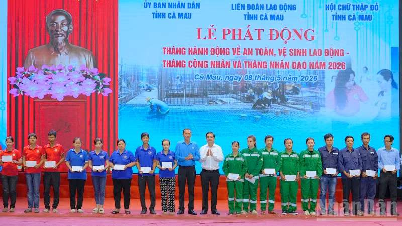Đại diện lãnh đạo tỉnh Cà Mau và Liên đoàn Lao động tỉnh (đứng giữa) trao quà tặng cho công nhân, công đoàn viên, người lao động tại lễ phát động.
