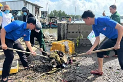 Đoàn viên thanh niên giúp người dân dọn bùn đất sau bão.