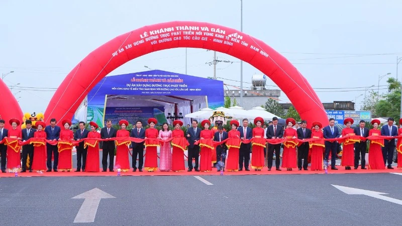 Các đồng chí Thường trực Tỉnh ủy và các đại biểu thực hiện nghi thức cắt băng khánh thành tuyến đường trục phát triển nối vùng kinh tế biển tỉnh với đường cao tốc Cầu Giẽ-Ninh Bình tại xã Yên Cường.