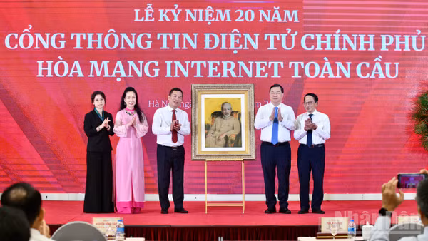 Phó Thủ tướng Thường trực Chính phủ Phạm Gia Túc trao quà lưu niệm tặng Cổng Thông tin điện tử Chính phủ. (Ảnh: THANH GIANG)