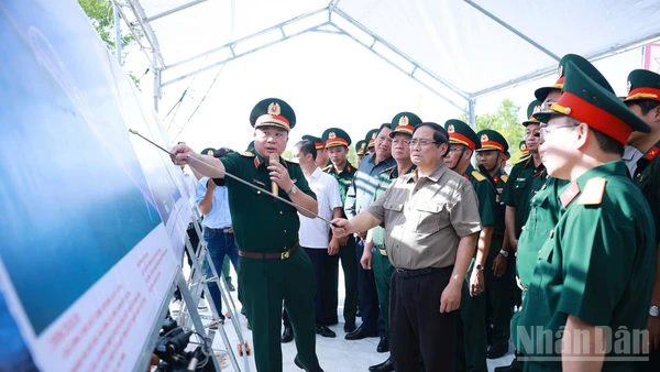 Thủ tướng Chính phủ Phạm Minh Chính nghe giới thiệu về tình hình triển khai các dự án trọng điểm trên địa bàn tỉnh Cà Mau. (Ảnh: Dương Giang/TTXVN)
