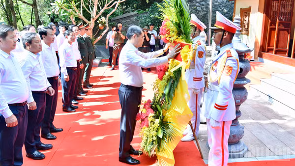 Thủ tướng Lê Minh Hưng chỉnh hoa trước khi vào dâng hương, dâng hoa tưởng niệm các Anh hùng liệt sĩ ở Khu di tích quốc gia đặc biệt hang Tám thanh niên xung phong. (Ảnh: Thanh Giang)