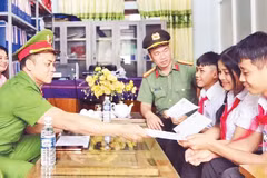 Đại úy Phạm Trần Lương Tri (ngoài cùng bên trái) cùng Chi đoàn Công an xã trao hỗ trợ hằng tháng cho các “Em nuôi của đoàn”.