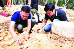 Chuyên gia khảo cổ và cán bộ Bảo tàng tỉnh Hà Giang xử lý di tích xuất lộ.