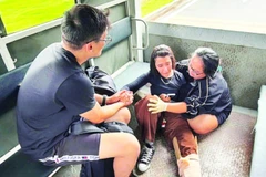 Kim Ngân (bên phải) trấn an và sơ cứu cho một du khách người Maroc bị gãy chân sau vụ va chạm giao thông trên Xa lộ Hà Nội.