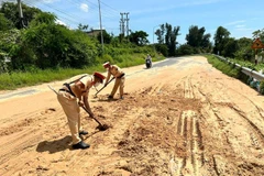 Lực lượng cảnh sát giao thông đang dọn cát.