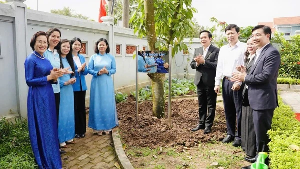 Các đại biểu tham gia trồng cây trong khuôn viên Nhà lưu niệm Lực lượng Nữ du kích Hoàng Ngân.