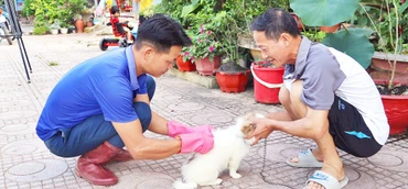 Cán bộ Trung tâm Dịch vụ nông nghiệp huyện Điện Biên Đông đến từng gia đình để tiêm vắc-xin phòng bệnh dại cho chó, mèo.