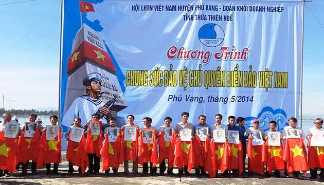 Trao cờ, chân dung Bác Hồ và Đại tướng Võ Nguyên Giáp cho ngư dân.