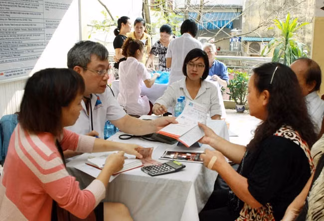 Nhân viên y tế tư vấn, hướng dẫn chăm sóc sức khỏe người cao tuổi. Ảnh: Dương Ngọc