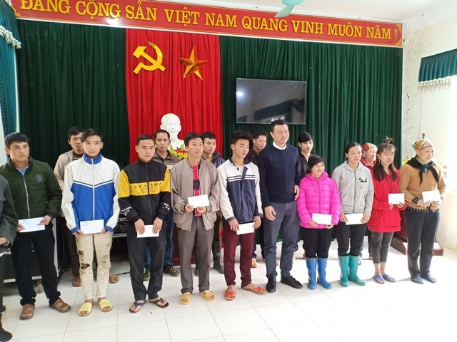 Đại diện Báo Nhân Dân trao quà cho các hộ nghèo.