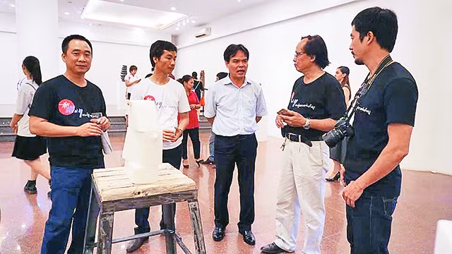 Các nghệ sĩ trao đổi tại triển lãm.