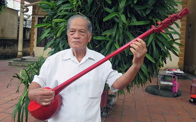 Nghệ sĩ Vi Tơ và cây đàn tính do ông chế tác.